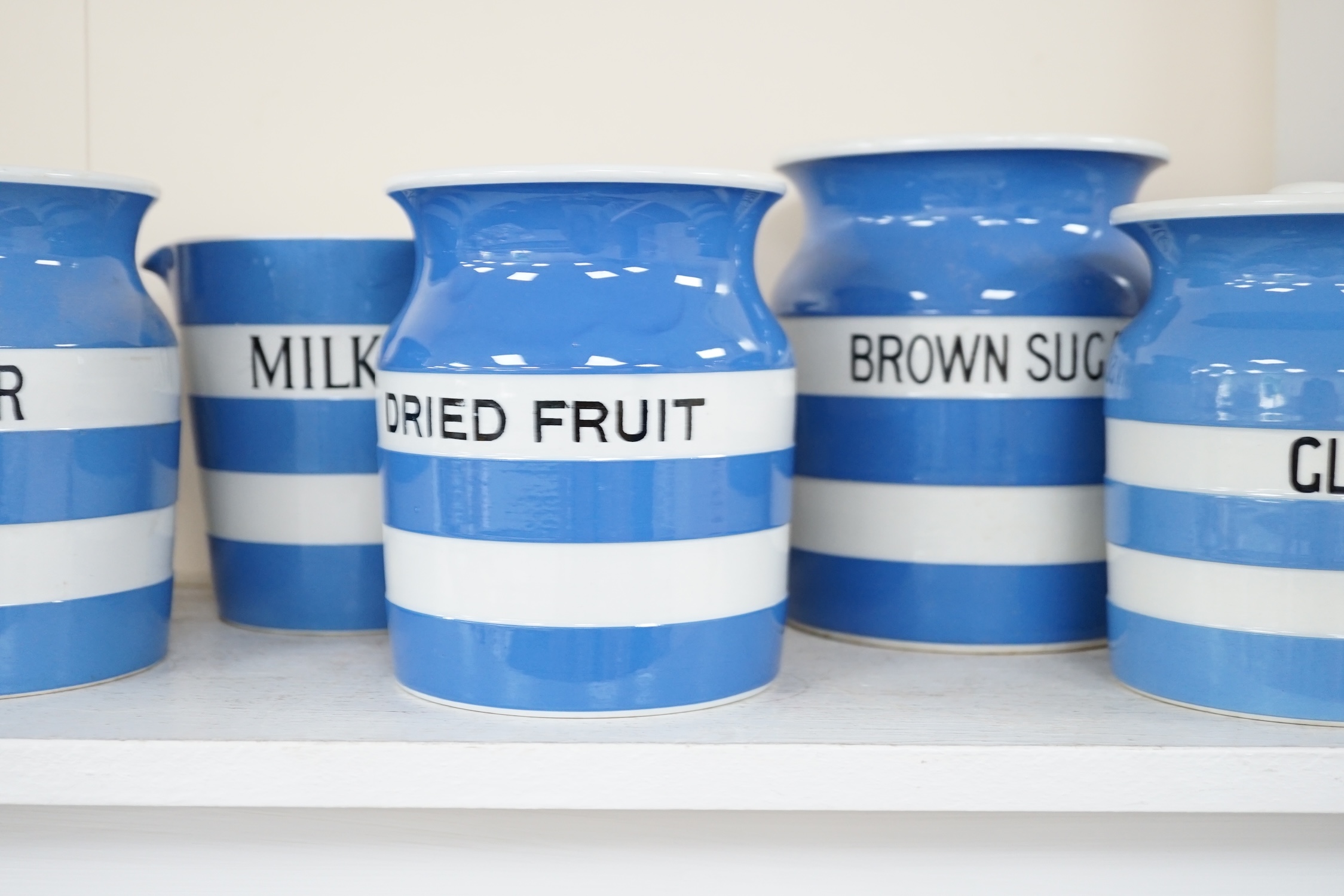 T.G.Green Cornish Kitchenware, nine lidded storage jars and two milk jugs to include Brown Sugar (2), Lump Sugar, Tea, Lentils and Dried Fruit, largest 17.5cm high, mixed marks. Condition - fair to good